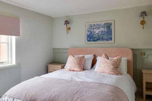 a bedroom with a bed with pink and white pillows at Luxury House - Walk to Racecourse - Sleeps 10 in Chester