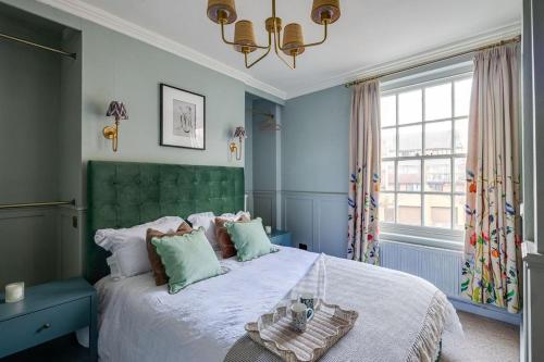 a bedroom with a large bed with a green headboard at Luxury House - Walk to Racecourse - Sleeps 10 in Chester