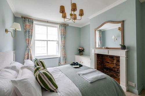 a bedroom with a bed with a fireplace and a mirror at Luxury House - Walk to Racecourse - Sleeps 10 in Chester