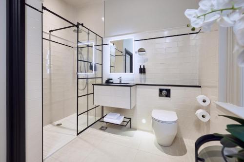 a bathroom with a toilet and a sink and a shower at The Bedford Hotel Belfast in Belfast