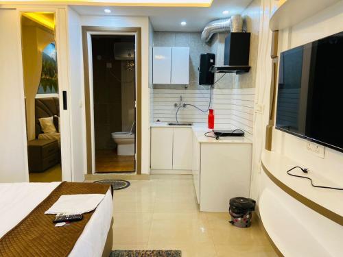 a room with a bed and a television and a bathroom at The Starfish Studio in Dehradun