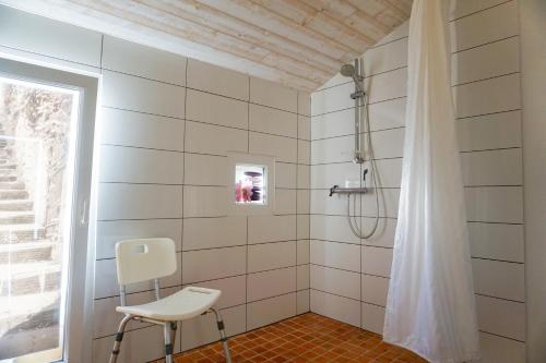 a bathroom with a shower and a white chair at chambres d'hôtes "DINEDORT" in LʼAiguillon-sur-Vie