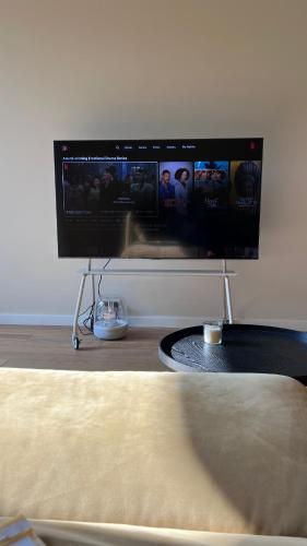 a flat screen tv hanging on a wall at Nette maisonnette in groene rustige wijk in Rijswijk