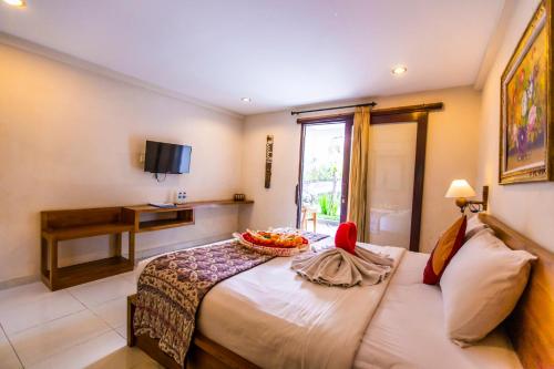 a bedroom with a bed with a bowl of fruit on it at Asri Sari Villa Ubud in Ubud