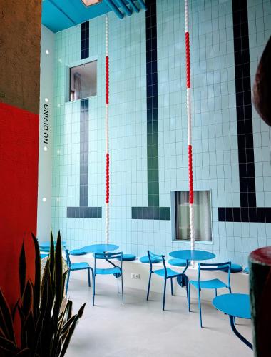 a group of blue tables and chairs in a room at Hotel Not Hotel Rotterdam in Rotterdam