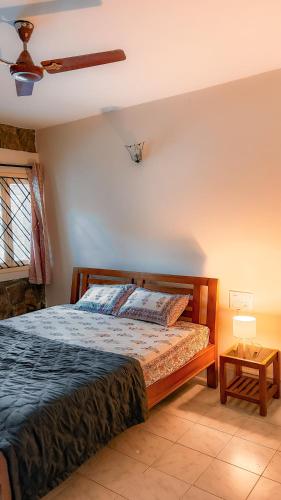 a bedroom with a bed and a ceiling fan at Auralis Experience in Jigani