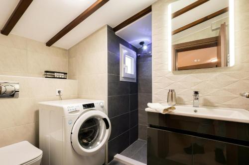 a bathroom with a washing machine and a sink at Meteora View Penthouse in Kalabaka