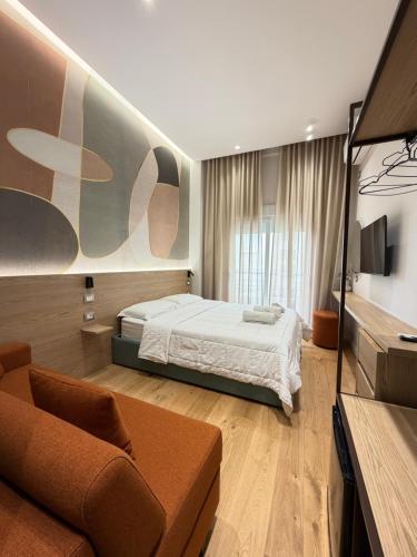 a bedroom with a bed and a couch at Xhani Boutique Rooms in Durrës