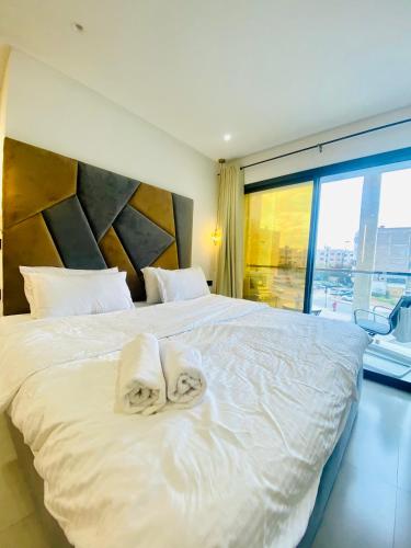 a bedroom with a large white bed with towels on it at nouvelle studio climatisé in Fez