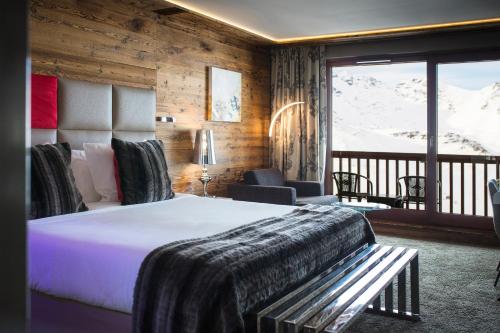 a bedroom with a bed and a balcony with snow at Hôtel Koh-I Nor by Les Etincelles in Val Thorens