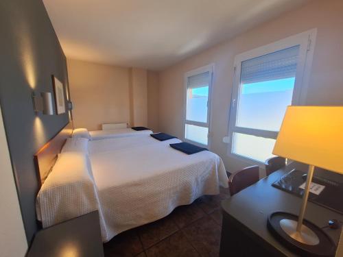 a hotel room with a bed and a window at Hotel Yerri in Estella