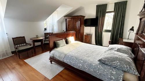 a bedroom with a bed and a table and a chair at Cyprianówka in Warszowice