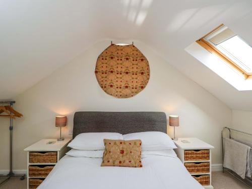 a bedroom with a white bed with two night stands at The Barn at Myrtle Cottage in Marlborough