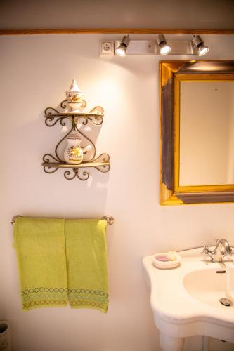 a bathroom with a sink and a mirror and a towel at Le Vieux Castel in Roumoules