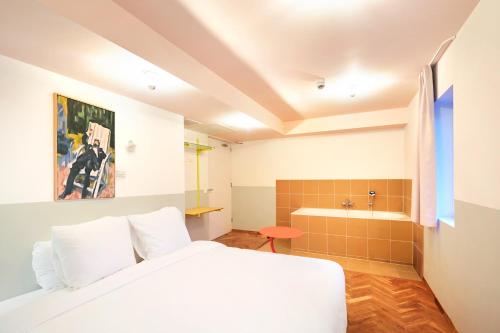 a bedroom with a bed and a tub and a sink at Hotel Not Hotel Rotterdam in Rotterdam