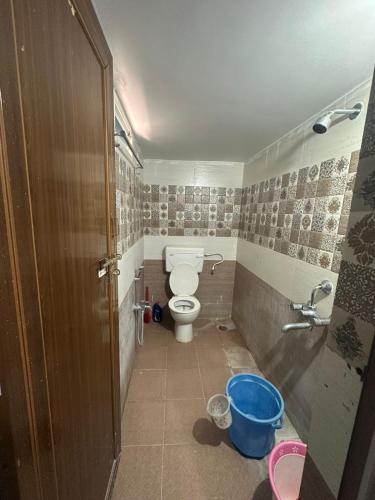 a small bathroom with a toilet and a shower at Hotel Moturi Farmstay Vemulawada in Vemalwāda