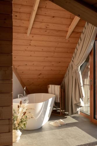 a bath tub in a bathroom with a wooden ceiling at Nova Hill in Zakopane