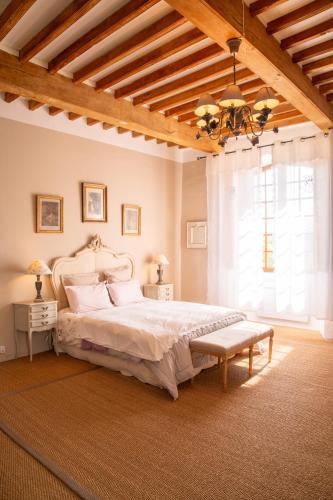 a bedroom with a bed and a large window at Le Vieux Castel in Roumoules