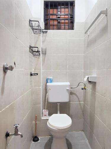 a small bathroom with a toilet and a window at COZY Two BEDROOM in Bamburi