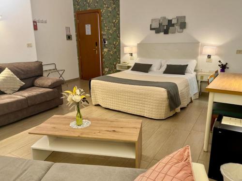 a hotel room with a bed and a living room at Hotel Arcadia in Macerata