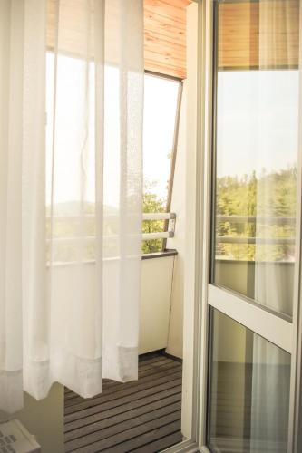 a room with a glass door and a window at Hotel Hrádok in Jelšava