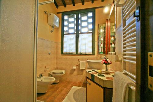 a bathroom with a sink and a toilet and a window at Casalecchi - Cottage between Siena & Florence in Poggibonsi