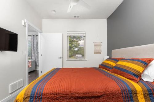 a white bedroom with a bed and a tv at The Pendleton Boutique Stylish 1 bedroom Condo in Traverse City