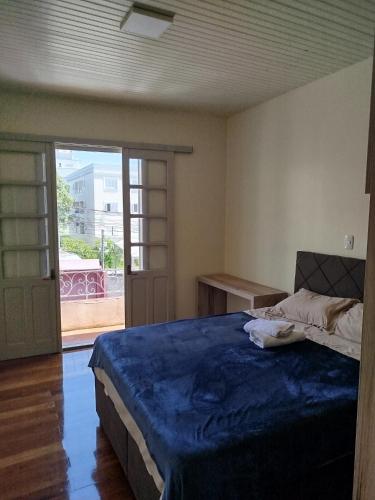 a bedroom with a bed and a door to a balcony at Casa da Nona in Garibaldi
