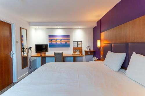 a hotel room with a large bed and a desk at TI Derby Escape - Free Wifi, Free Parking in Derby