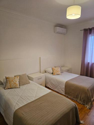 a bedroom with two beds and a window at Santa Maria Goldcrest House in Vila do Porto