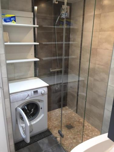 a bathroom with a washing machine and a glass shower at Maisonnette Les Coraux residence prive avec piscine in Canet-en-Roussillon