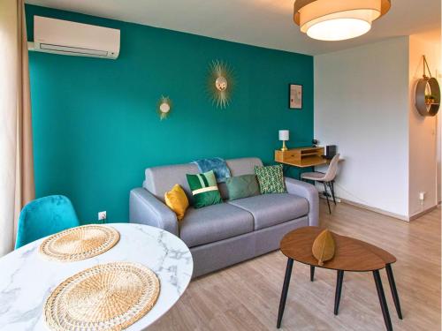 a living room with a couch and a table at Le Pic'Vert - Escapade Solo ou Duo - Hôpital à 400m - Parking gratuit - GARE & CENTRE HISTORIQUE 15min à pied - Clim - Balcon au calme in Bergerac
