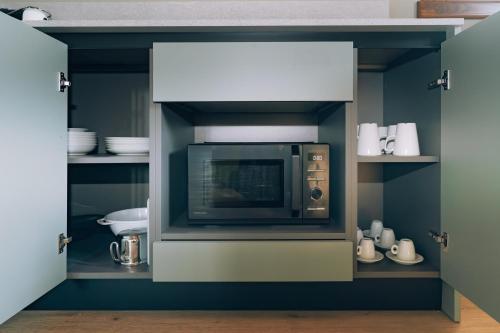 a kitchen with a microwave oven in a cabinet at Legnago Suite Apartments in Legnago