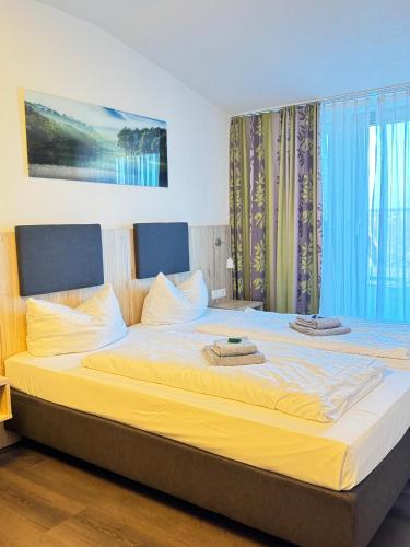 a bedroom with a large bed with towels on it at Küffner Hof in Langenbeutingen