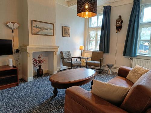 a living room with a couch and a table at Voorhuis 2 personen - De Kruidenhoeve in het Reestdal - in Balkbrug