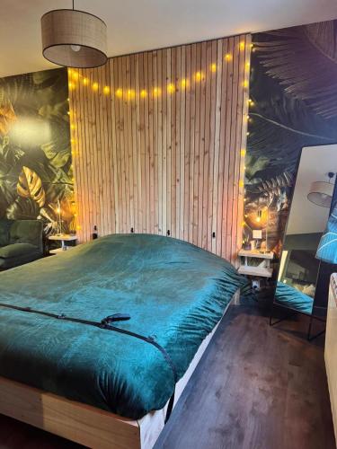 a bedroom with a large green bed in it at Le miroir des désirs in Argentré-du-Plessis