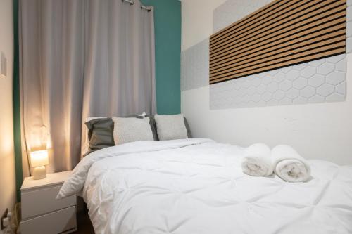 a bedroom with a white bed with towels on it at Seafront Flat in Brighton Marine Parade in Worthing