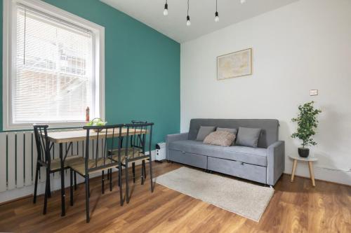 a living room with a couch and a table at Seafront Flat in Brighton Marine Parade in Worthing