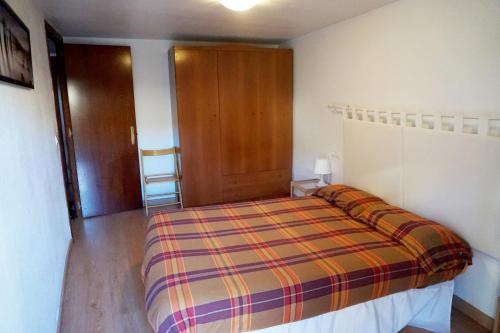 a bedroom with a bed and a wooden door at Apartamentos Turísticos Río Gallego (Apartamento Huesca) in Huesca