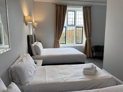 a hotel room with two beds and a window at Southcrest Manor Hotel, Best Western Signature Collection in Redditch