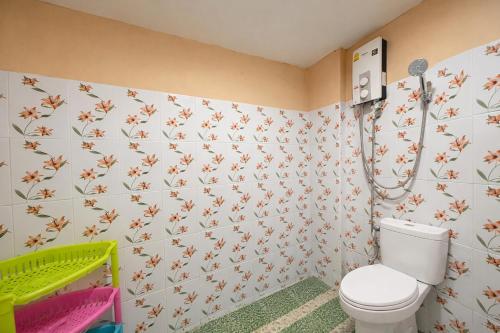a bathroom with a toilet and flowers on the wall at FHR Krabi City Hotel in Krabi