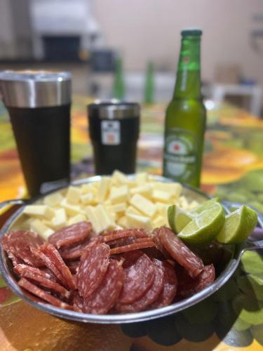 a plate of meat and cheese and a bottle of soda at Pesqueiro Rancho dos Reis in Aquidavana