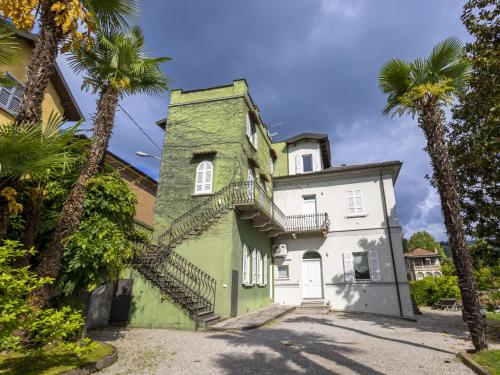 an old house with palm trees in front of it at Apartment Le Gemme-3 by Interhome in Meina