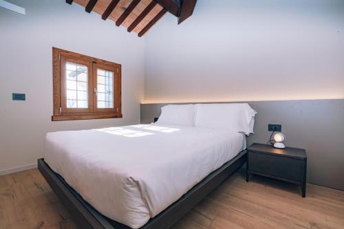 a bedroom with a large white bed and a window at Legnago Suite Apartments in Legnago