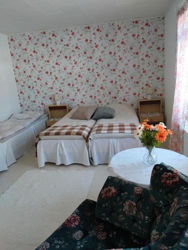 a bedroom with two beds and a couch and a table at Störsby Bed & Breakfast in Lappers