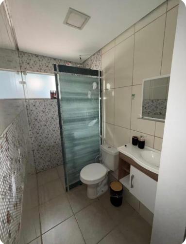 a bathroom with a toilet and a shower and a sink at Your Climatized Paradise in Americana