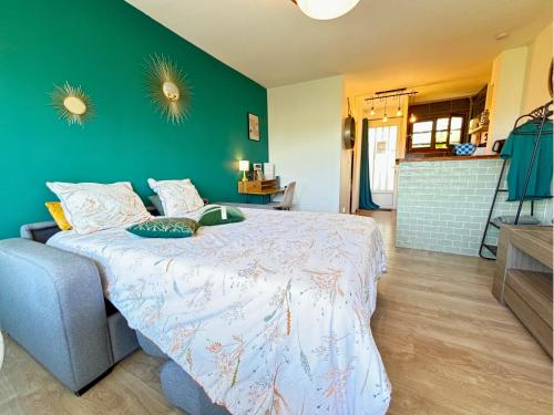 a bedroom with a bed and a green wall at Le Pic'Vert - Escapade Solo ou Duo - Hôpital à 400m - Parking gratuit - GARE & CENTRE HISTORIQUE 15min à pied - Clim - Balcon au calme in Bergerac