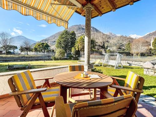 a table and chairs on a patio with a playground at Apartment Carlui by Interhome in Domaso