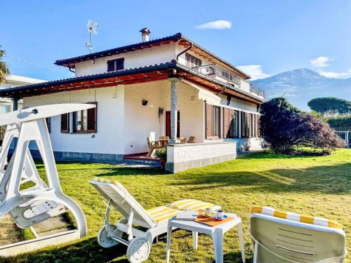 a house with a lawn with a chair and a table at Apartment Carlui by Interhome in Domaso