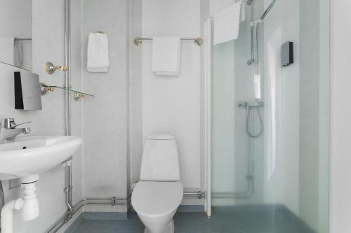 a white bathroom with a toilet and a sink at Best Western Hotel Bollnas in Bollnäs